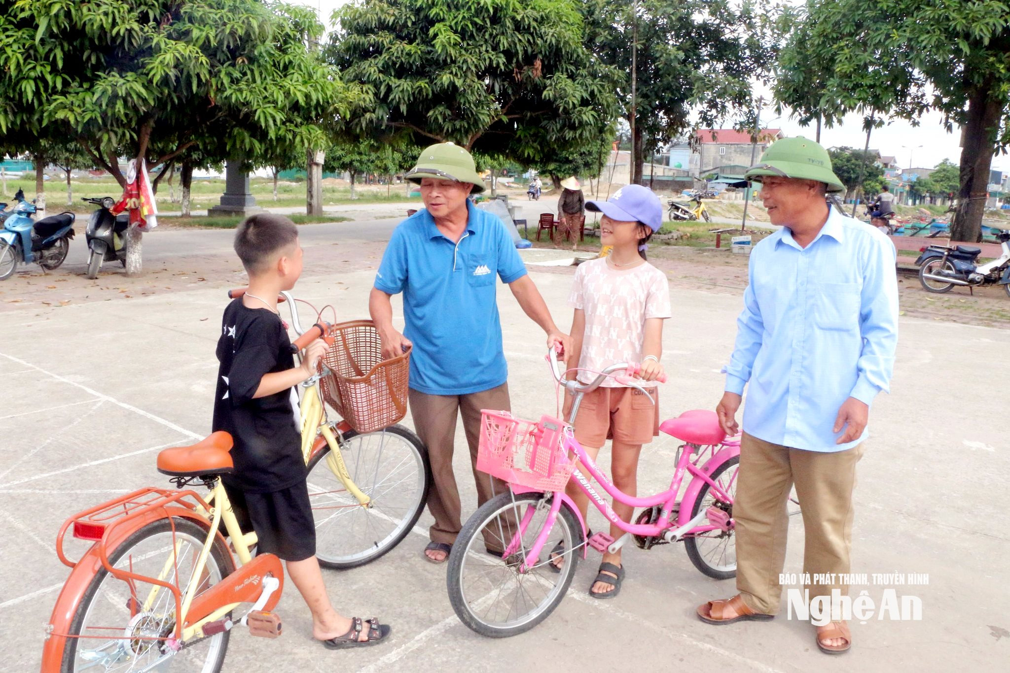 Ông Phùng Bá Huynh (áo phông cộc tay) trò chuyện với các cháu thiếu nhi tại khu vực đã được cải tạo thành sân chơi, bãi tập. Ảnh KL