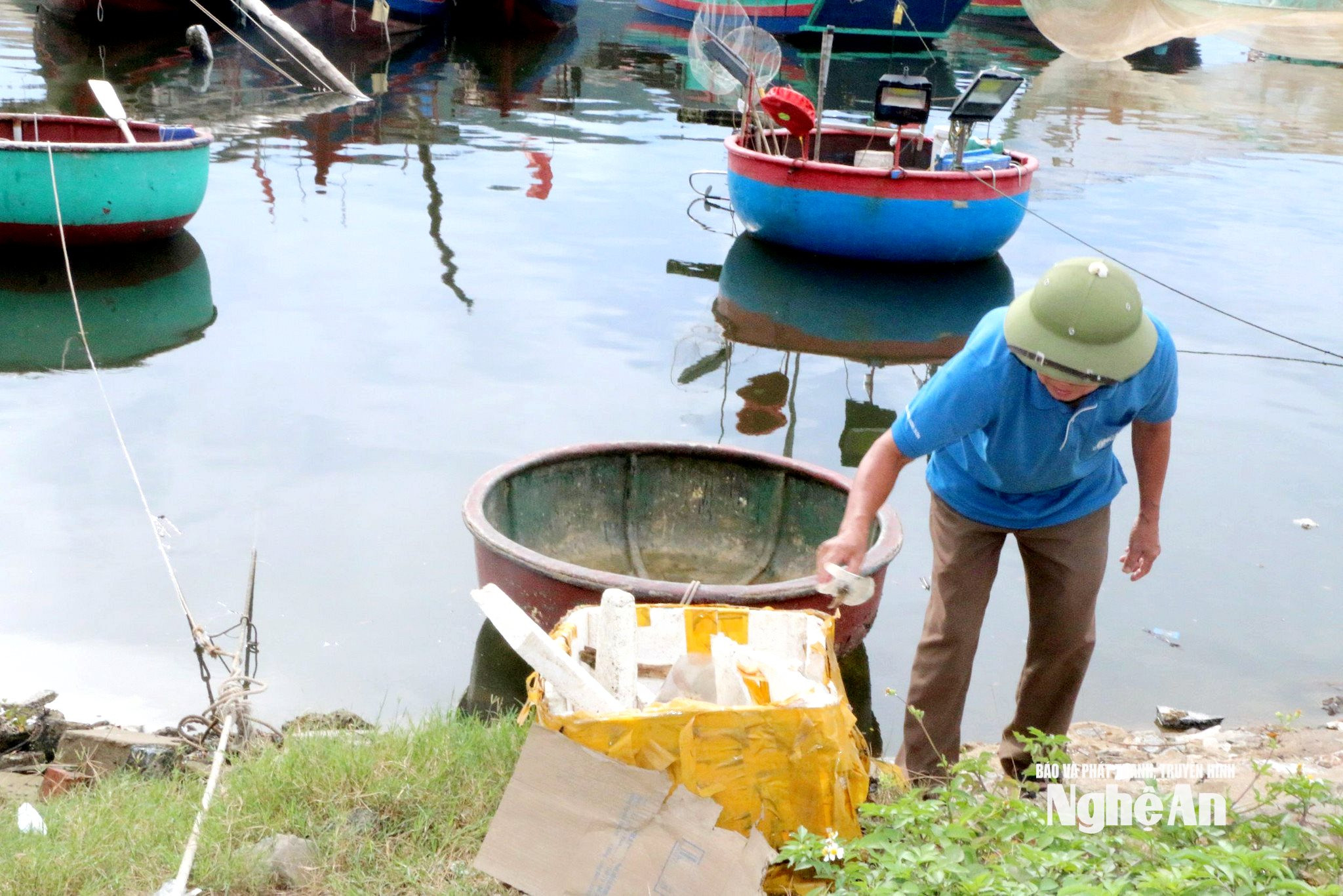 Ông Phùng Bá Huynh - Khối trưởng khối Yên Đình dọn rác ở khu vực sông gần bến cá Nghi Thủy, thị xã Cửa Lò. Ảnh KL