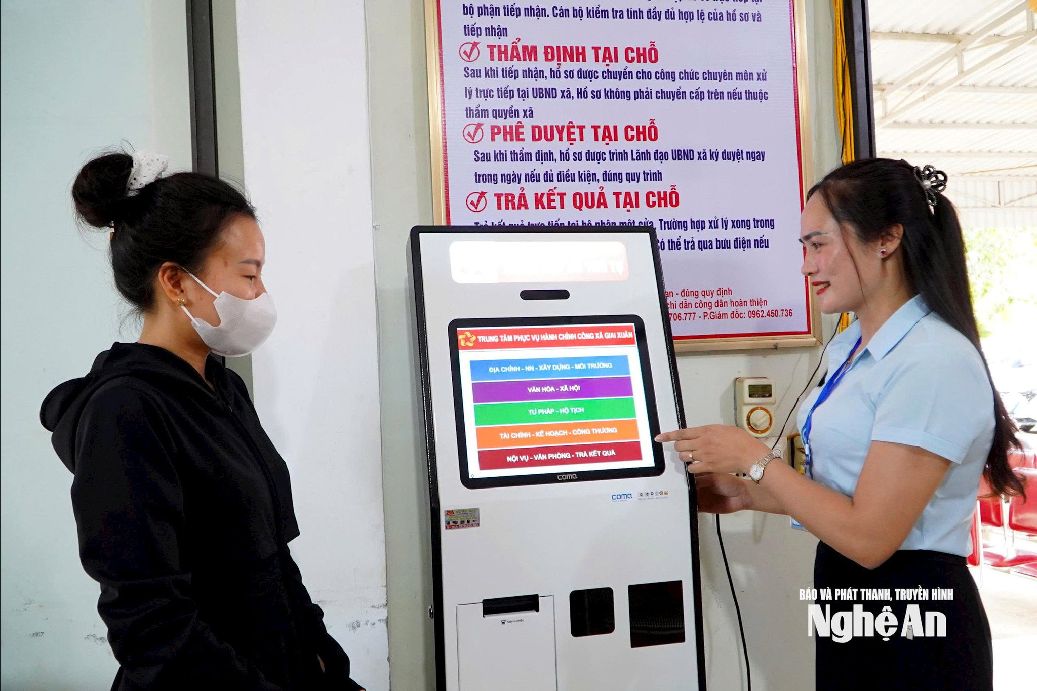 Cán bộ của bộ phận một cửa xã Giai Xuân hướng dẫn người dân thực hiện thủ tục đăng ký làm việc. Ảnh: Bông Mai