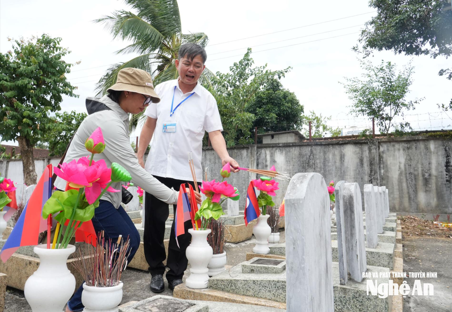 Cán bộ quản trang Nghĩa trang liệt sĩ Quốc tế Việt - Lào chia sẻ câu chuyện về ngôi mộ đôi đặc biệt. Ảnh: Diệp Thanh