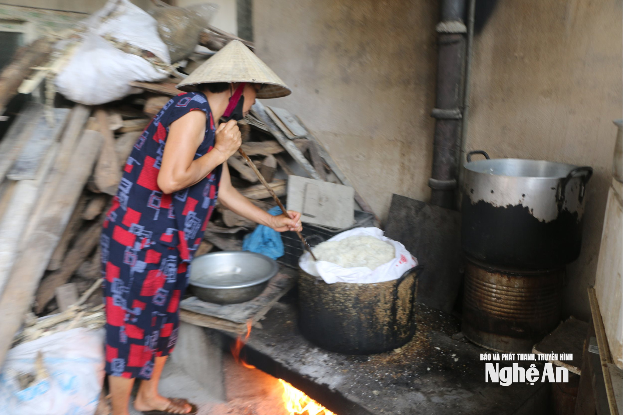 Bà Nguyễn Thị Hồng - một trong những hộ sản xuất tương quy mô lớn ở khối Mai Hắc Đế, xã Vạn An đảo xôi nếp để làm mốc. Ảnh KL