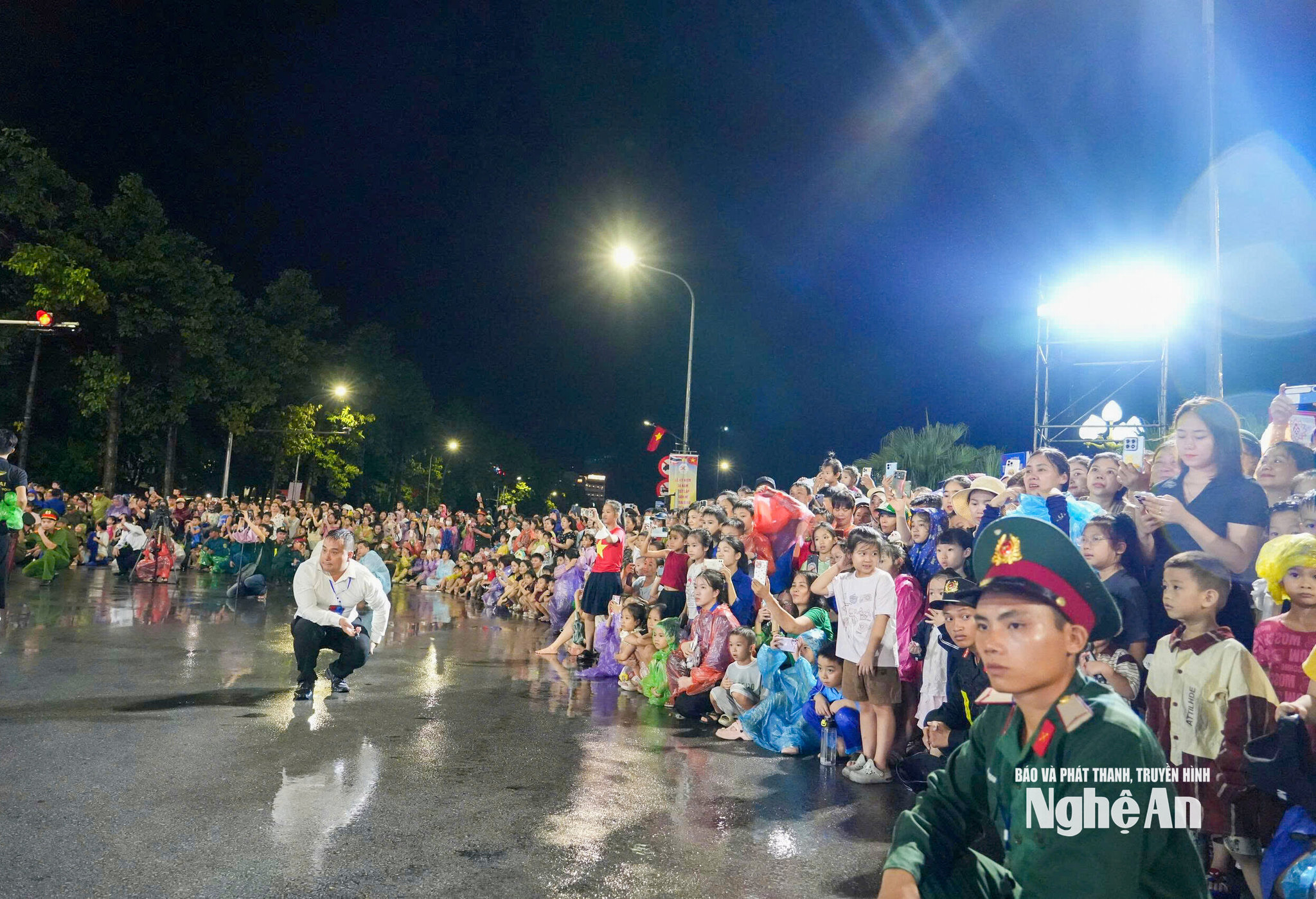 Mặt đường Trường Thi còn ướt sau trận mưa lớn, nhưng đông đảo người dân vẫn đứng kín hai bên đường theo dõi Carnival Nghệ An 2026.