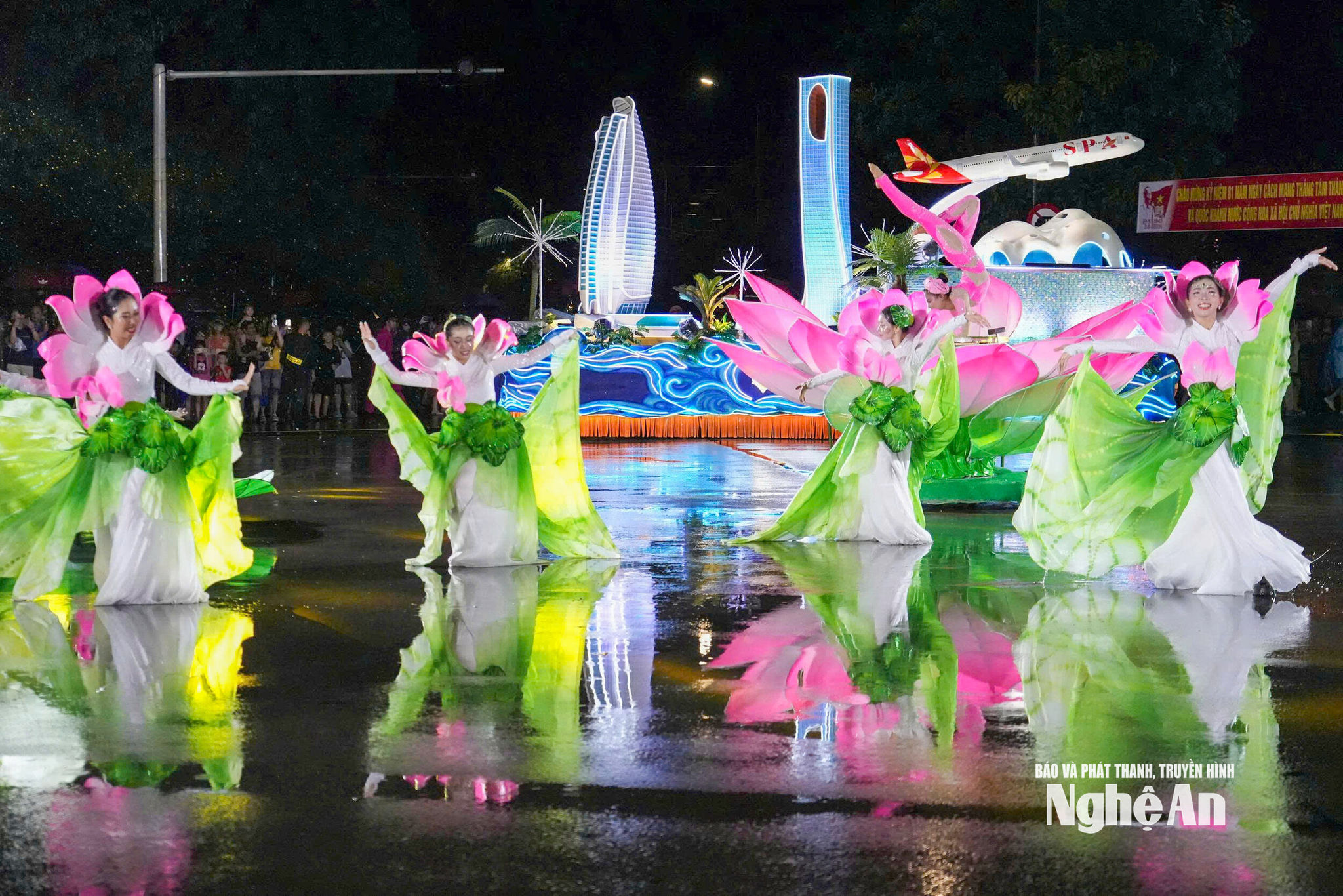 Tốp Hoa Sen biểu diễn trên nền đường loang nước, đưa hình tượng sen – một nét nhận diện gần gũi của Nghệ An vào không gian Carnival hiện đại.