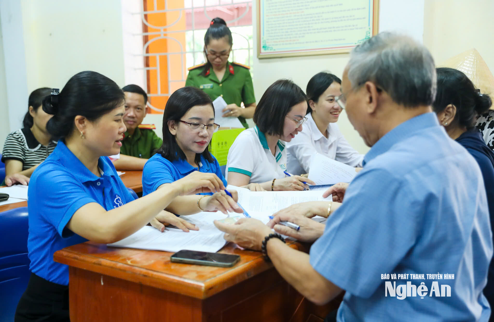 Cơ quan BHXH phối hợp các ngành liên quan hướng dẫn người dân nhận lương hưu qua tài khoản cá nhân. Ảnh Đức Anh