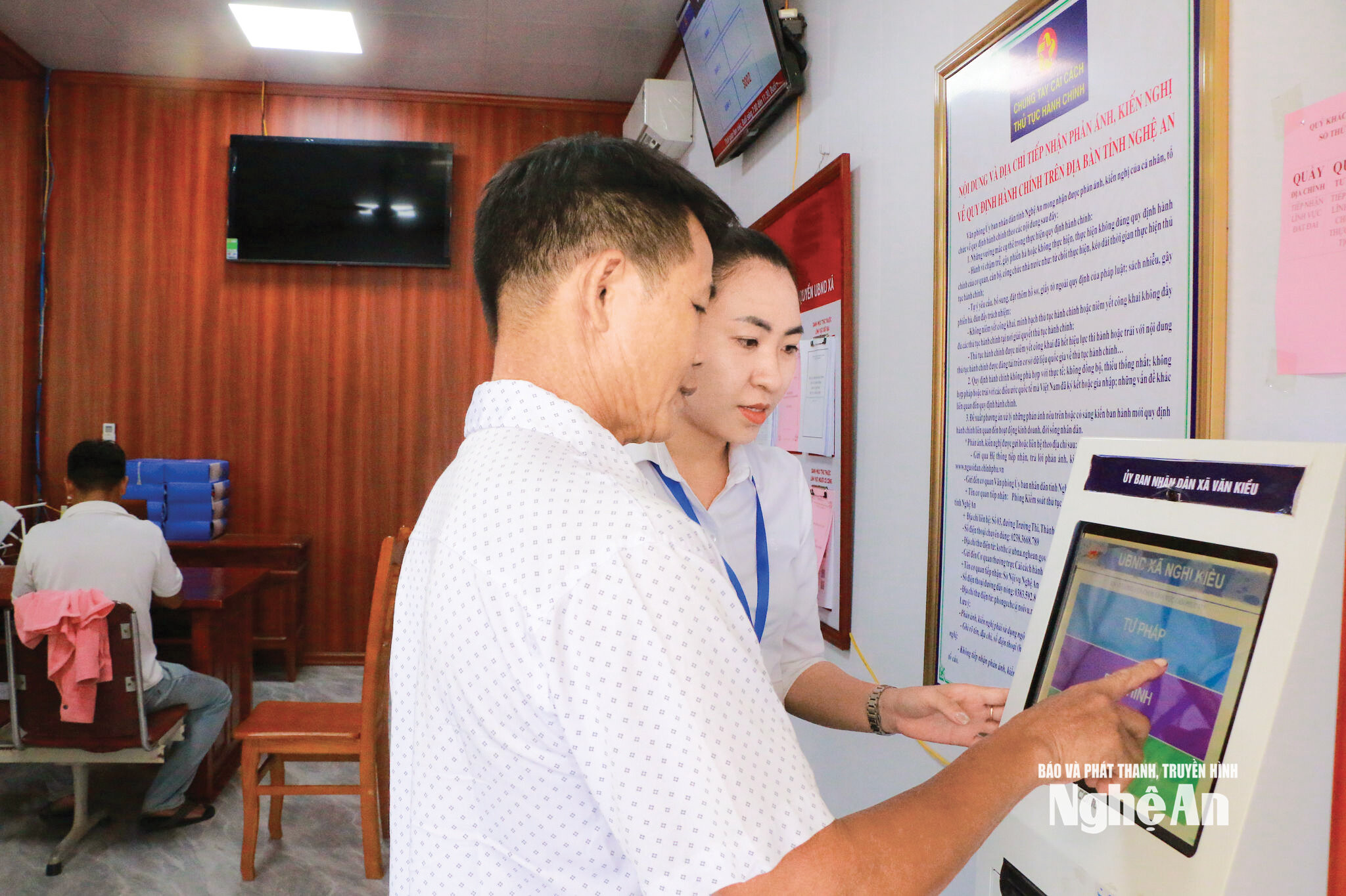 Cán bộ xã Văn Kiều hướng dẫn người dân đăng ký trực tuyến. Ảnh KL