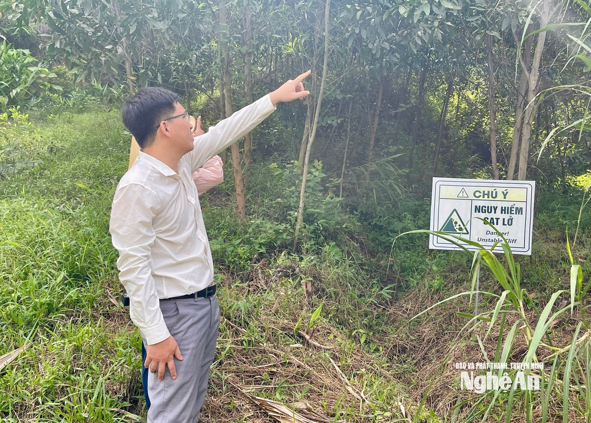 Vị trí sườn núi phía sau khu dân cư từng xảy ra sạt lở được cắm biển cảnh báo nguy hiểm. Ảnh: Quang Minh