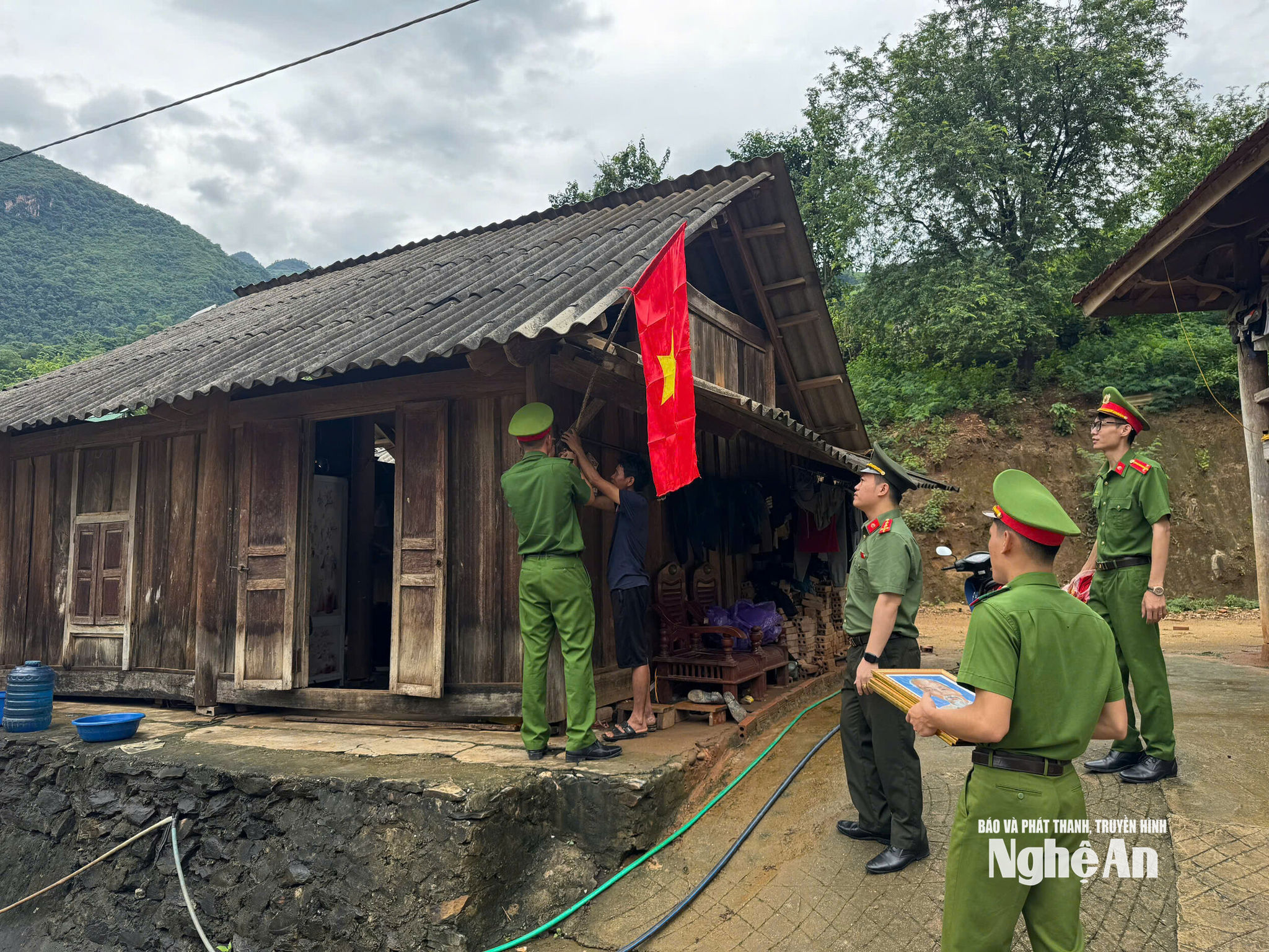 Dịp này, Công an xã Mường Xén trao 100 ảnh Bác Hồ và 100 lá cờ Tổ quốc đến các gia đình trên địa bàn, trong đó có những hộ được Bộ Công an hỗ trợ xây dựng nhà lắp ghép. Ảnh: Tiến Thành