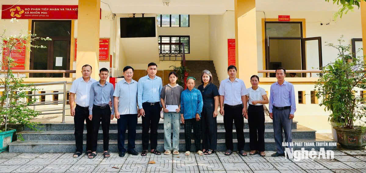 Cán bộ Đảng uỷ xã Nhôn Mai tặng quà cho con đỡ đầu Xồng Thu Tranh. Ảnh GH