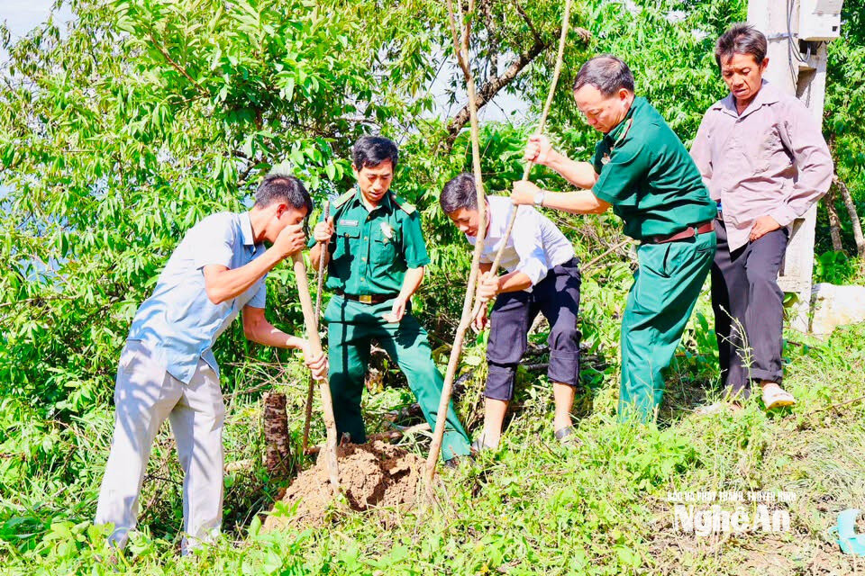 Cán bộ và lực lượng chức năng trên địa bàn xã Nhôn Mai tham gia trồng cây cùng người dân. Ảnh CSCC