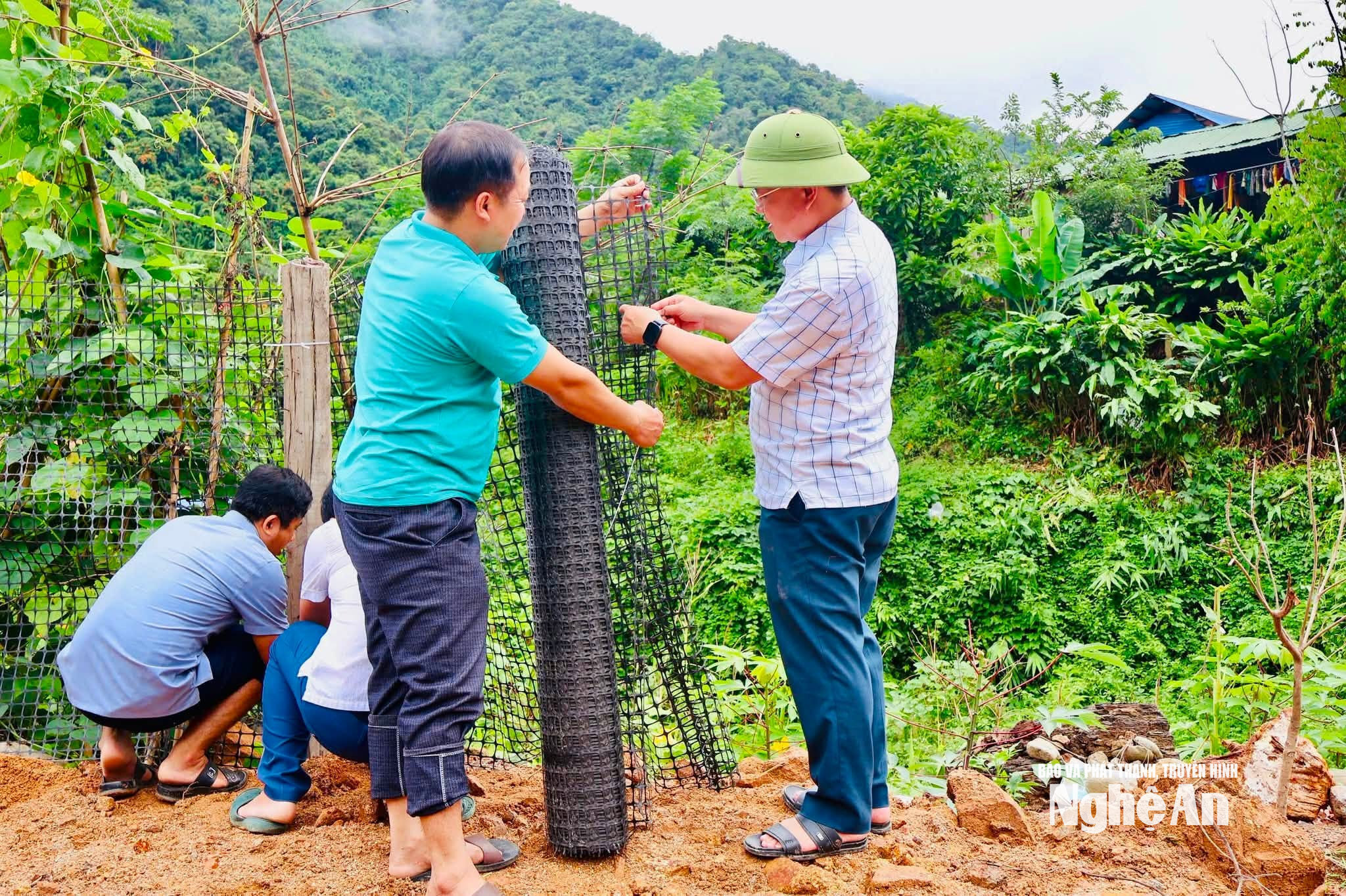 Cán bộ xã Nhôn Mai dựng hàng rào triển khi mô hình 'Vườn rau con nuôi'