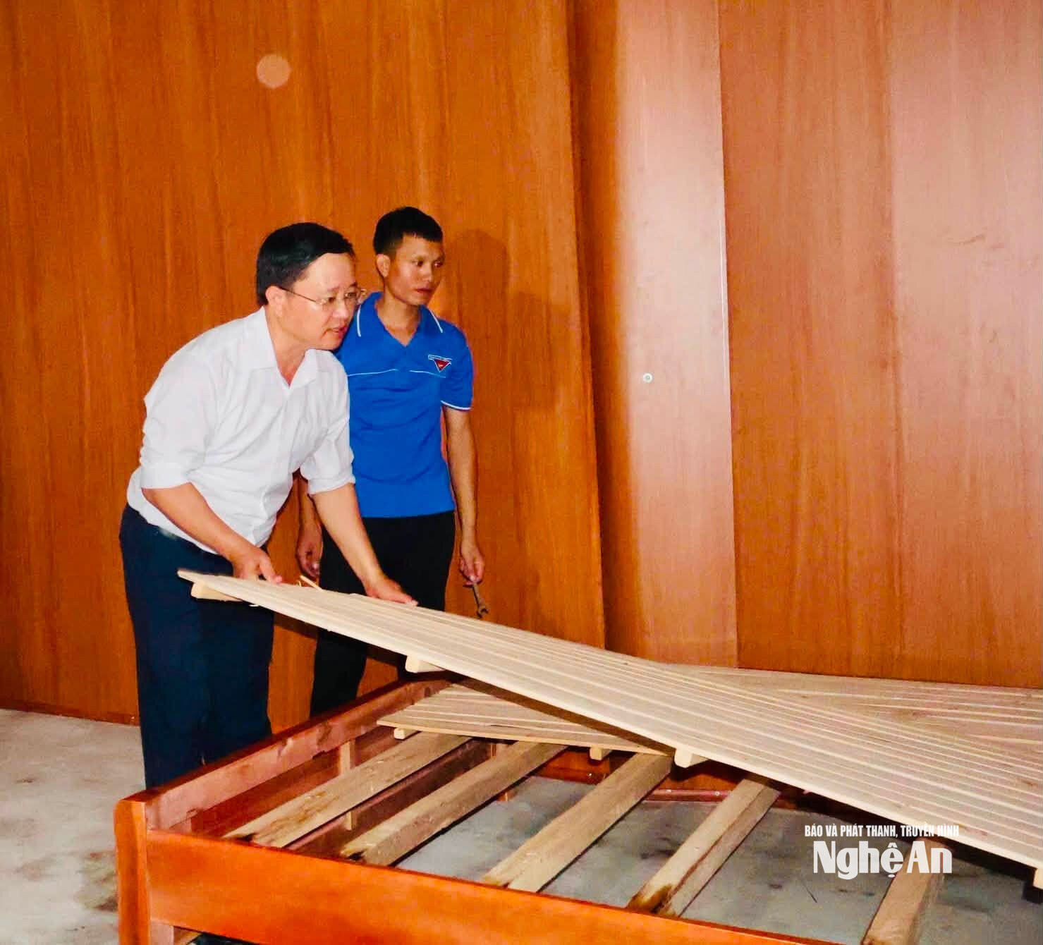 Cán bộ xã Nhôn Mai lắp giường tặng cho em Xồng Thu Tranh. Ảnh GH