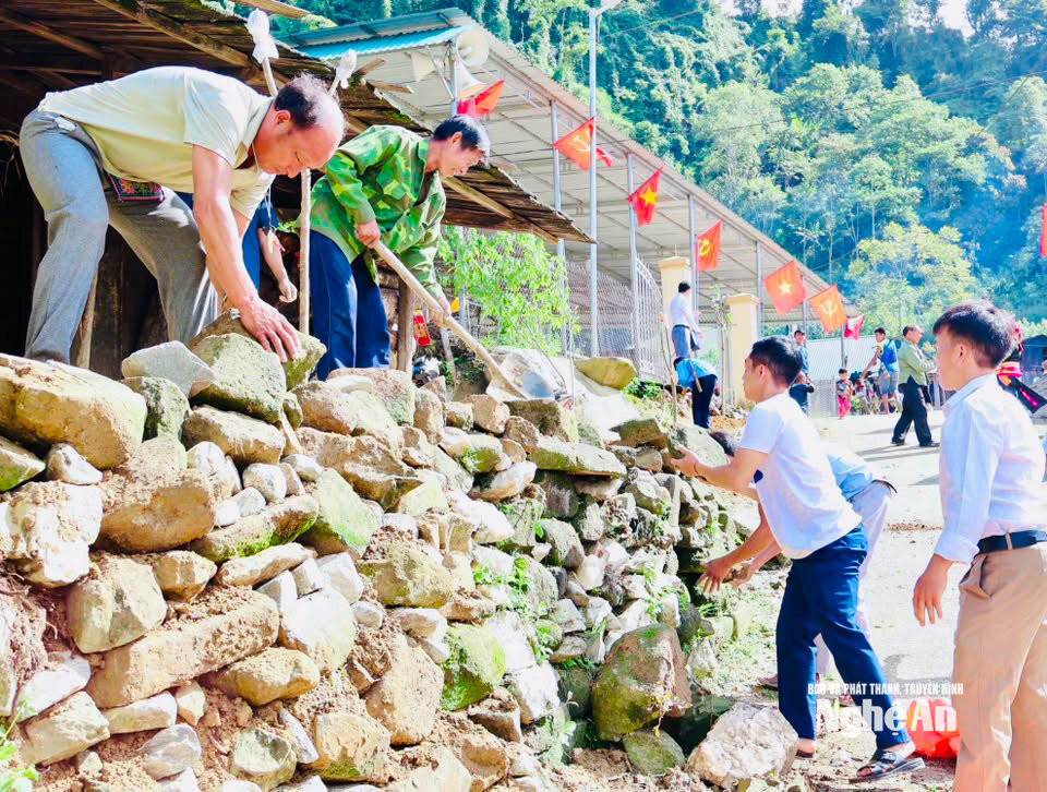 Cán bộ xã Nhôn Mai và người dân bản Huồi Cọ dựng bờ kè đá, trồng đào làm đẹp cảnh quan. Ảnh GH