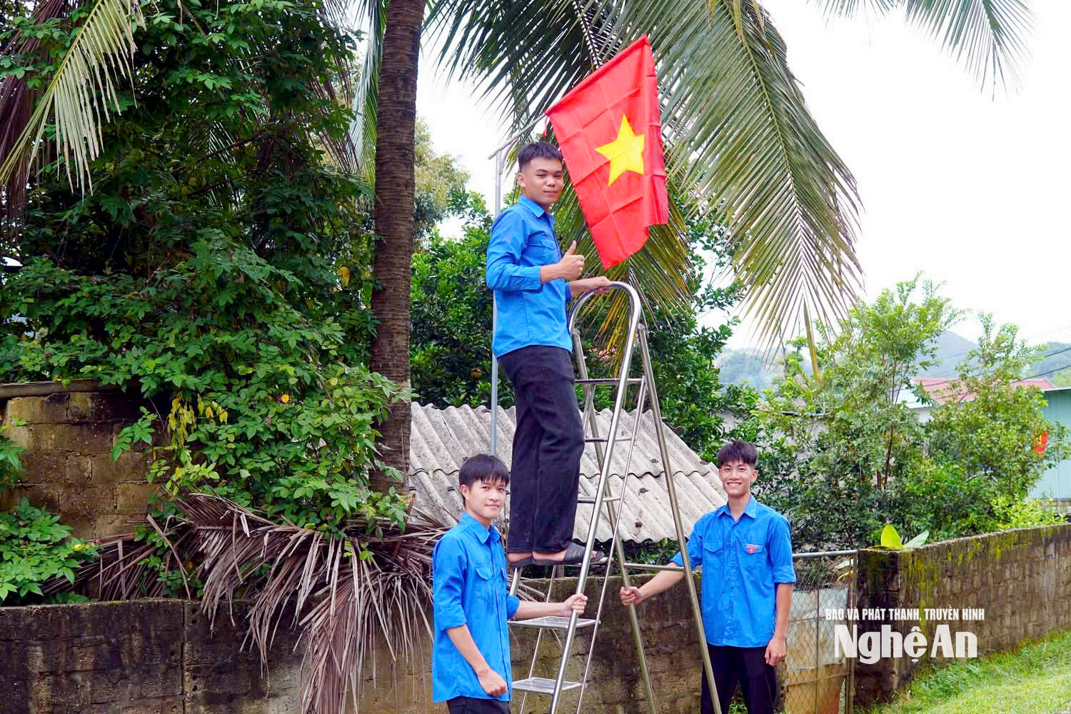 Thanh niên xóm Đại Cường treo cờ tổ quôc dọc các tuyến đường. Ảnh CSCC