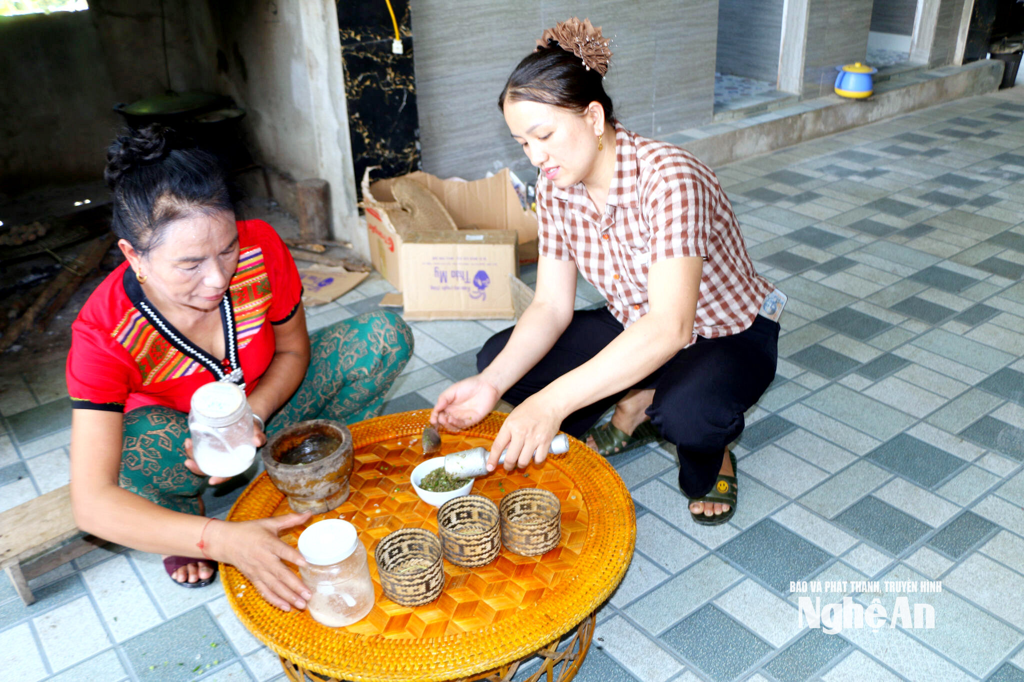 XÓm Trưởng Vi Thị Phượng tham gia chế biến món ăn truyền thống của đồng bào dân tộc Thái. Ảnh TP