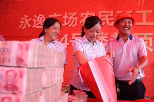 Công nhân Trung Quốc đem bao tải đi lĩnh tiền