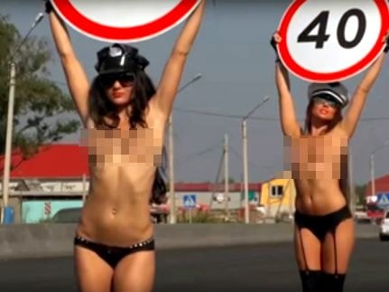 Mỹ nữ ngực trần xuống đường, giơ biển báo giảm tốc