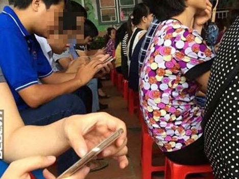 Bức ảnh cha mẹ đi họp phụ huynh ngồi lướt điện thoại gây xôn xao
