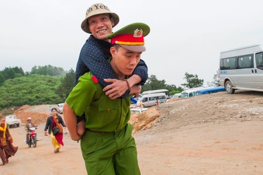 Chiến sỹ công an cõng người tàn tật lên chùa
