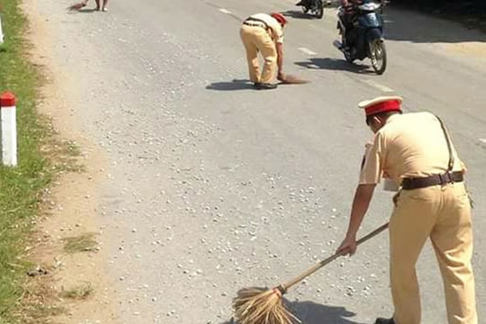 Công an cùng người dân đội nắng dọn đá dăm rơi vãi dọc đường