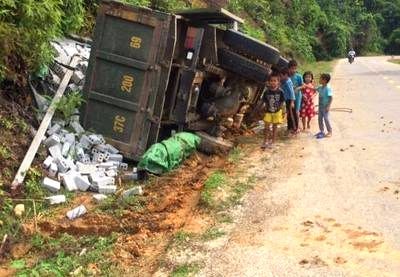 Xe tải lật, lái xe mắc kẹt trong cabin