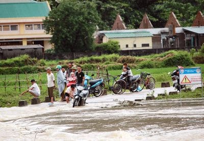 Hàng trăm người dân ngồi chờ nước rút để qua cầu