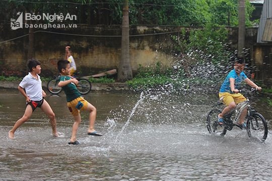 Phố biến thành sông, trẻ con hồn nhiên đùa nghịch