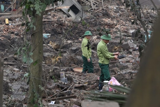 Người chồng băng qua đống đổ nát của kho phế liệu đưa vợ đi cấp cứu