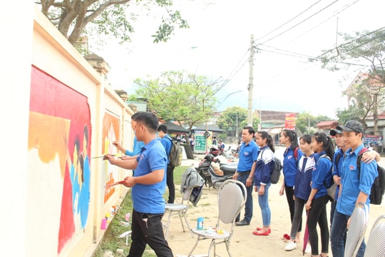 Thanh niên miền núi trang trí bờ rào trường học bằng tranh cổ động 