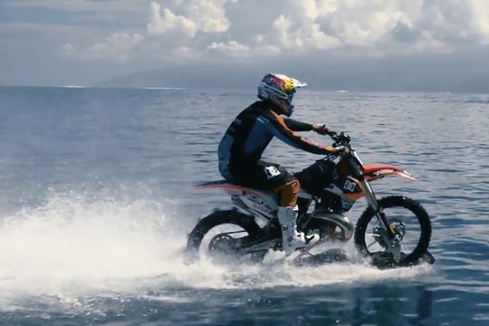 Người đàn ông lái xe máy chạy phăng phăng trên mặt nước