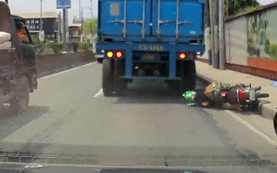 Bị bánh xe tải chèn qua đầu, tài xế xe máy đứng dậy sau vài giây