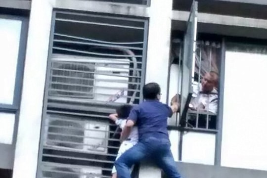 Ông bố trèo ra ngoài cửa sổ tầng 7 chung cư cứu con