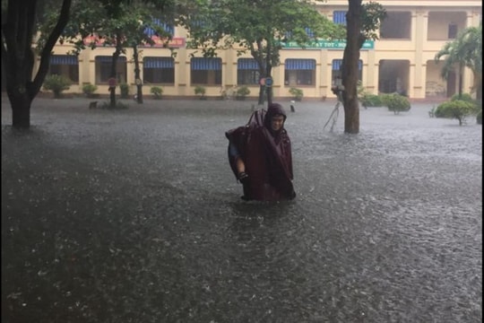 Phụ huynh bì bõm cõng con giữa trời mưa như trút ở thành Vinh