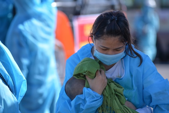 Nhiều bà mẹ trẻ bồng con trở về từ Bắc Giang