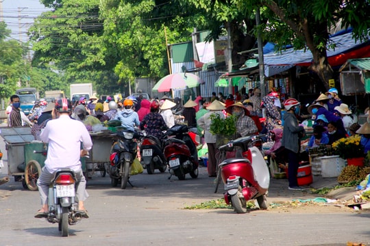 Người dân chen chúc mua bán hàng trước cổng chợ đầu mối Vinh
