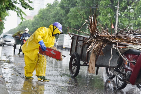 Công nhân vệ sinh môi trường dầm mưa quét dọn rác, khơi thông cống