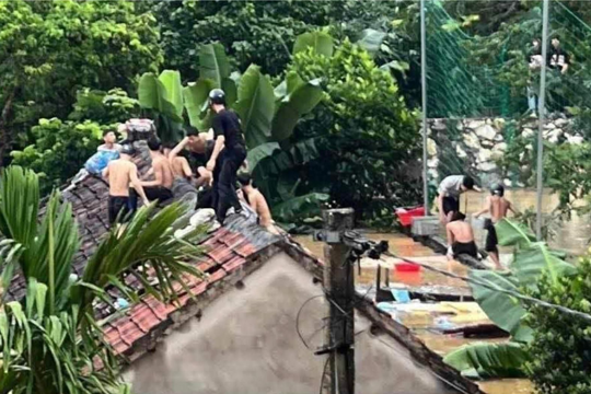 Hàng chục học sinh phải trèo lên nóc nhà cầu cứu trong mưa lũ