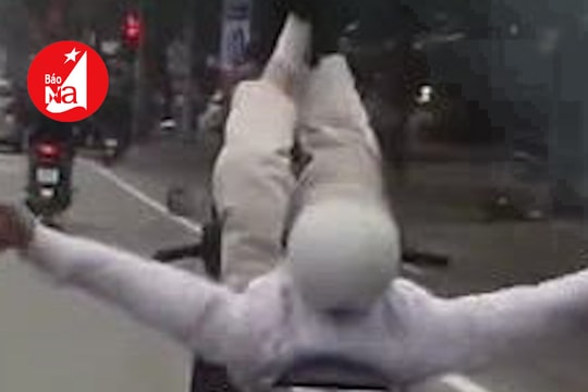 Người đàn ông thả 2 tay, nằm dài gác chân khi điều khiển xe máy