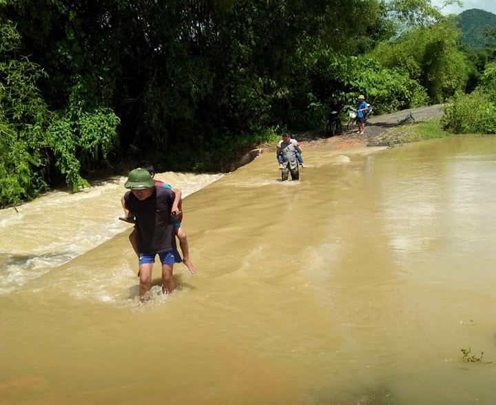 Phụ huynh ở Nghệ An liều mình đưa con em đi học trong nước lũ chảy xiết