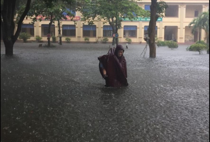 Phụ huynh bì bõm cõng con giữa trời mưa như trút ở thành Vinh