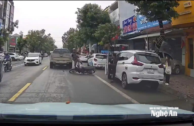 Vừa lái xe máy vừa nghe điện thoại, người đàn ông ngã ra đường khi ô tô bất ngờ mở cửa